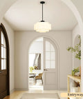 puncoll Vintage Black Milk Glass Pendant Light, 15.7'' White Chandelier hanging in an entryway illuminating the space.