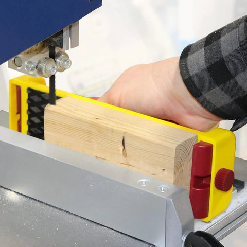 Hand using GrabberPLUS Pushblock For Table Saws Router Tables Band Saws And Jointers Yellow With Diamond Grip Rubber Bottom on bandsaw