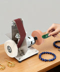 Rock Solid 7 Speed Mini Belt Sander Featuring Ultra Quiet Performance And 20 Tough Sanding Belts For Precision Woodworking Glass Etching And Detailed Jewelry Grinding On Any Weekend Warrior Build Back At The Local Shop in use on a table with jewelry items.