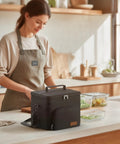 Woman preparing food next to Premium 9 Liter Soft Sided Cooler Bag With Leak Proof Design Keeps Your Grub Fresh All Day Superior Triple Layer Insulation Durable 600D Oxford Cloth Thermal Lunch Tote.