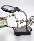 4X LED Magnifier Soldering Station With Light, Adjustable Stand and Auxiliary Clips holding a PCB for detailed work.