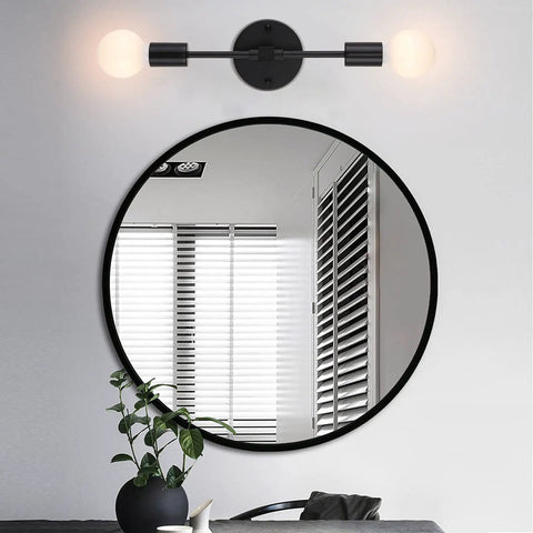 Dual Light Bathroom Wall Sconce Vanity Fixture In Gold And Black Finish above a round mirror in modern bathroom setting