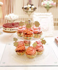Cupcakes on a clear 2-tiered stand atop a Tempered Glass Cutting Boards Set For Kitchen Counters 2 Pack 16x12 And 12x8 Inches