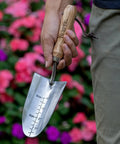 Person holding 13 Inch Stainless Steel Garden Trowel With Oak Handle And Leather Wrist Strap Built To Last For Digging And Planting