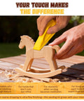 Using 128 Piece Pro Grade Premium Micro Sander And Sandpaper Kit to smooth wooden toy horse outdoors.