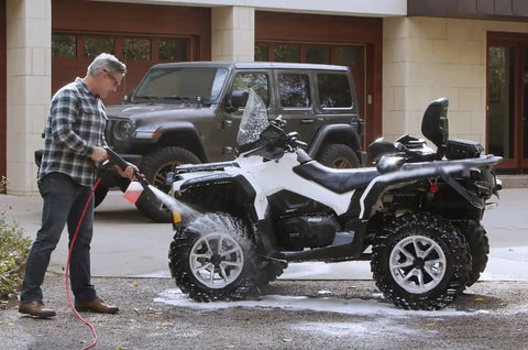 Man using Electric Pressure Washer 1600 PSI 1.7 GPM Portable Cleaner for Cars, Siding, Driveways, and Patio on an ATV