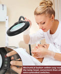 8X Magnifying Glass With Light On A Stand, being used by a beautician during a facial treatment, showcasing a 24 inch flexible gooseneck.