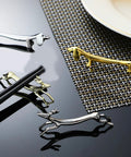 Stainless Steel Cutlery Holder Rack with gold-toned animal design on a black reflective surface, modern tableware display