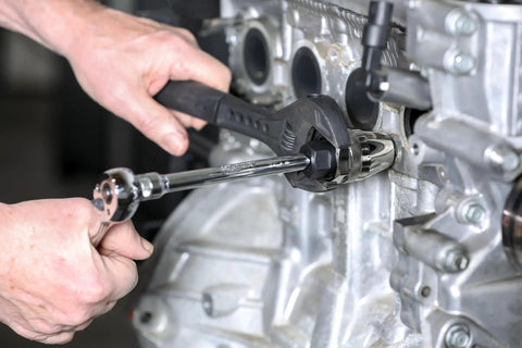 Damaged Bolt And Stud Extractor For One Quarter To One Half Inch Studs Grips Tight And Removes Broken Rounded Off Painted Over And Rusted Tight Bolts Three Eighths Inch Drive Tool For Manual And Pneumatic Wrenches in use on engine with wrench
