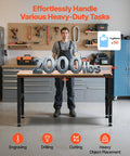 Person standing beside Heavy Duty Adjustable Workbench With 2000 Lb Capacity 61 By 20 Inch Surface Height Adjustable From 27.1 To 36 Inches Built In Power Outlets Perfect For Garage Shop Or Office, showcasing weight capacity.