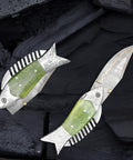 Fish Style Copper Damascus Folding Knife With Ladder Pattern Blade, brass engraved handle, open and closed on dark background