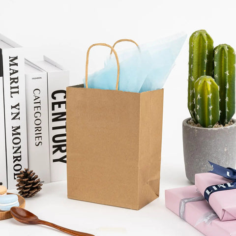 100 Pack Small Brown Kraft Paper Gift Bags With Handles 5.8x3.2x8.25 Inches Natural Kraft Bags for party favors on a table