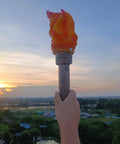 Realistic Flameless LED Torch Light Prop Lamp For Parties, handheld style, against sunset in outdoor setting