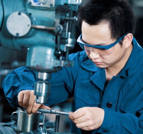 Donepart 684ZZ bearings, 4x9x4 mm, double shielded and pre-lubricated; technician in safety glasses handling components.