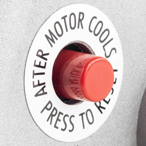 Red reset button labeled 'Press to Reset' on a heavy duty electric motor. Important for operation after cooling.