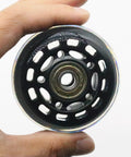 Hand holding 2.5 Inch Inline Skate Wheels 64mm With ABEC7 Bearings, 82A Hardness, Black, for skates, office chairs, and luggage