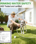 Person using Upgraded Metal Garden Hose Reel With 100 Ft Main Hose And 6.2 Ft Guide Hose to water dog on lawn with safety certificate
