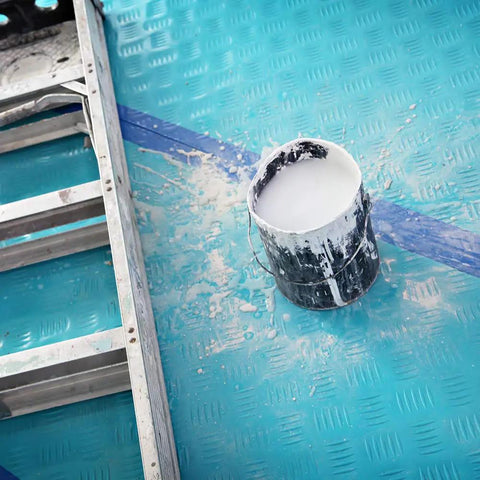 Aqua Shield Surface Protector 10 Mil 36 Inch By 100 Foot Heavy Duty Protective Film with a paint spill next to a ladder on blue surface.