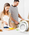Space Saving Acrylic Paper Plate Dispenser For 5 To 12 Inch Plates shown on kitchen countertop with two people cooking