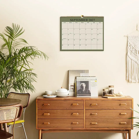 Nail Your 2026 to 2027 Game Plan With This 18 Month Wall Calendar Spanning August 2026 to December 2027 in Green with Twin Wire Binding displayed on a wall.