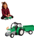 Child playing with 7-Inch Tractor Toy With Lights And Sounds, Movable Parts and Detachable Trailer with Rear Hatch on white background