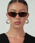 Woman wearing Retro Oval Sunglasses For Women With Cat Eye 90s Vibe Lightweight Narrow Frames UV Protection Sun Glasses