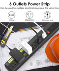 Built Tough Heavy Duty 20 Amp Power Strip With 6 Widely Spaced Outlets next to an orange hard hat and tools on a workbench
