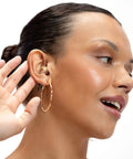 Woman wearing High Fidelity Earplugs For Concerts And Festivals Reusable Nightlife Ear Protection in gold color