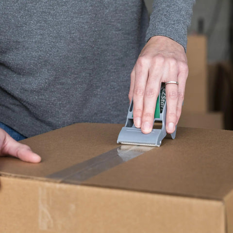 Person using EZ Start Packing Tape With One Handed Dispenser 1.88 Inch By 55.5 Yard Crystal Clear Tape Roll to seal a box.
