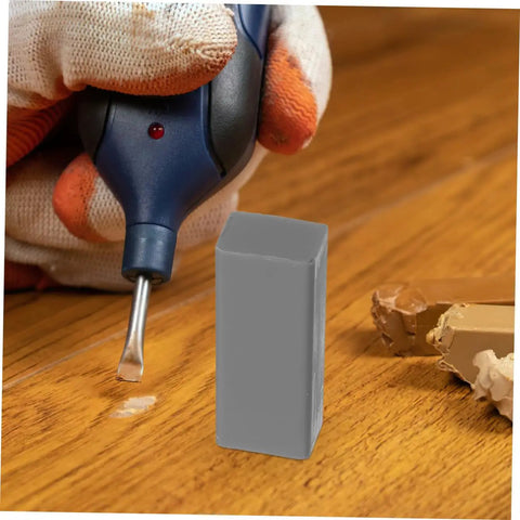 Gloved hand using DIY Floor Repair Kit For Cracked Tiles And Surfaces With Wax Block, Quick Heat Technology on wooden floor