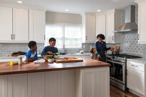 Family cooking in modern kitchen with VoiceIQ Activation Module for Touch2O Kitchen Faucets Compatible with Alexa and Google Assistant.