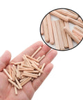 Hand holding Wooden Dowel Pin Set 48 Pcs, 4mm By 30mm And 5/32 Inch By 1.18 Inch, fluted beveled end pins for shelf support.