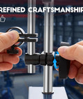 Hands adjusting heavy duty magnetic base stand with fine adjustment for dial indicator, showing solid metal construction.