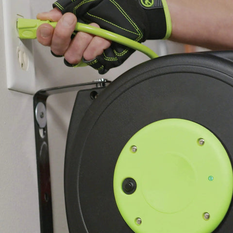 Close-up of Retractable 25 Ft Extension Cord Reel With 16/3 SJTOW Oil Resistant Cable being plugged into a wall outlet