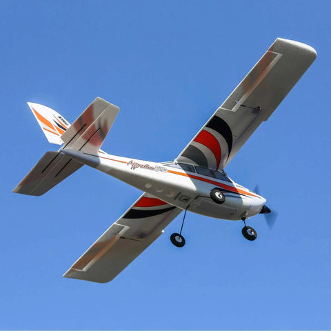 Big 1.5 Meter RC Airplane Trainer With Safe Flight System, BNF Basic, Easy To Fly For Beginners At The Club Field, High Visibility, Stable In Variable Winds, Transmitter And Charger Not Included, silver and orange plane in flight, view from below against blue sky