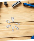 Six Piece Set Of One Inch White Nylon Sliding Roller Guide Wheels For Heavy Duty Furniture And Cabinet Drawer Tracks featuring smooth sliding guides on wooden surface.