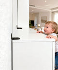 Child standing beside furniture secured with Anti Tip Furniture Anchor Kit For Baby Proofing Dresser And Bookcase, Easy Wall Mount.