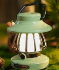Close-up of a green kid friendly lantern with three color modes and USB C charging on a mossy surface