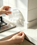 Crystal Clear Self Adhesive Waterproof Tape For Heavy Duty Sealing Bathtub Shower And Kitchen Sink With Invisible Finish that shows application on countertop.