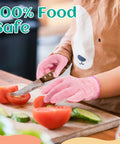 Child wearing pink Kids Cut Resistant Gloves Level 5 Protection For Cooking Wood Carving Whittling Gardening And DIY Projects Food Grade Safe Small Size For Ages 4-6 Years Pink Green Or Gray, slicing tomatoes.