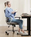Woman sitting on an Ergonomic Mid Back Mesh Office Chair With Wheels And Lumbar Support For Home And Office, Grey, at a desk