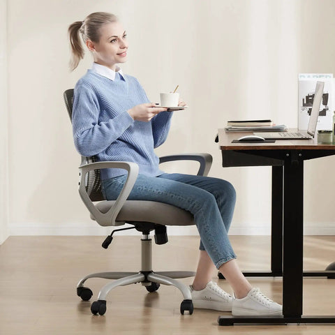Woman sitting on an Ergonomic Mid Back Mesh Office Chair With Wheels And Lumbar Support For Home And Office, Grey, at a desk