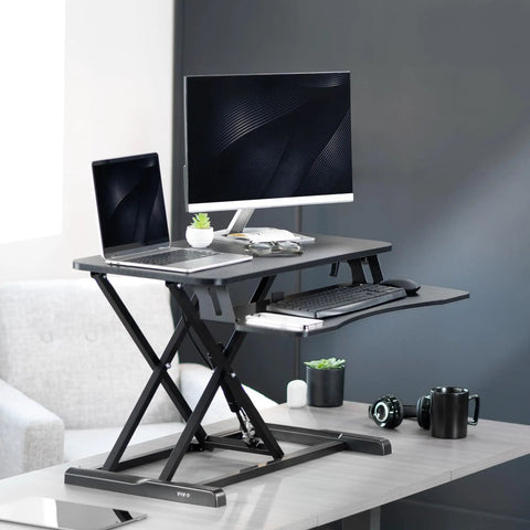 32 Inch Desk Converter K Series Sit To Stand Riser With Dual Monitor And Laptop Workspace Height Adjustable Standing Desk Attachment Wide Keyboard Tray Black DESK V000K with monitors and a laptop on a raised surface.