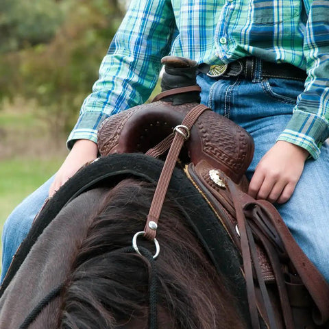 Close-up of adjustable bungee rein attached to saddle, showing waterproof polypropylene construction and carabiner O-ring.