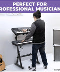 Musician using Two Tier Piano Keyboard Stand With Adjustable Height And Width For Synths And Electric Keyboards Gig Ready Portable Heavy Duty Music Stand Compatible With All Major Keyboard Brands Fits 54 61 And 88 Key Pianos in studio setting