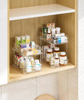 Slick Clear Under Sink Organizers And Storage Bins 2 Pack with stacked toiletries and medicines in a bathroom cabinet.