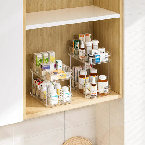 Slick Clear Under Sink Organizers And Storage Bins 2 Pack with stacked toiletries and medicines in a bathroom cabinet.
