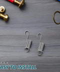Top Notch 12-Piece Mini Stainless Steel Extension Springs Kit With Secure Hooks And Wire Pulling Clips For Quick Graphic Swaps On Display Boards Perfect For Shop Repairs And Tough Industrial Jobs With Durable Galvanized Metal For Maximum Stability. Two mini stainless steel extension springs with hooks on gray wood