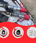 Two 1/2 in NPT skid-steer hydraulic quick-connect couplers with red dust caps, ISO16028 flat-face, 5076 PSI