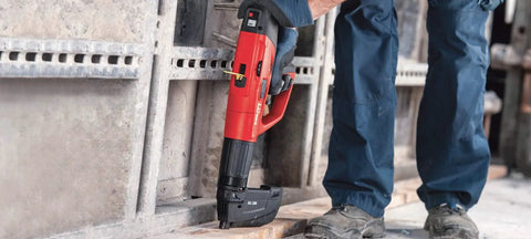 Worker using powder actuated fastener cartridge for concrete and steel, .27 caliber, short 6.8/11 mm, on construction site